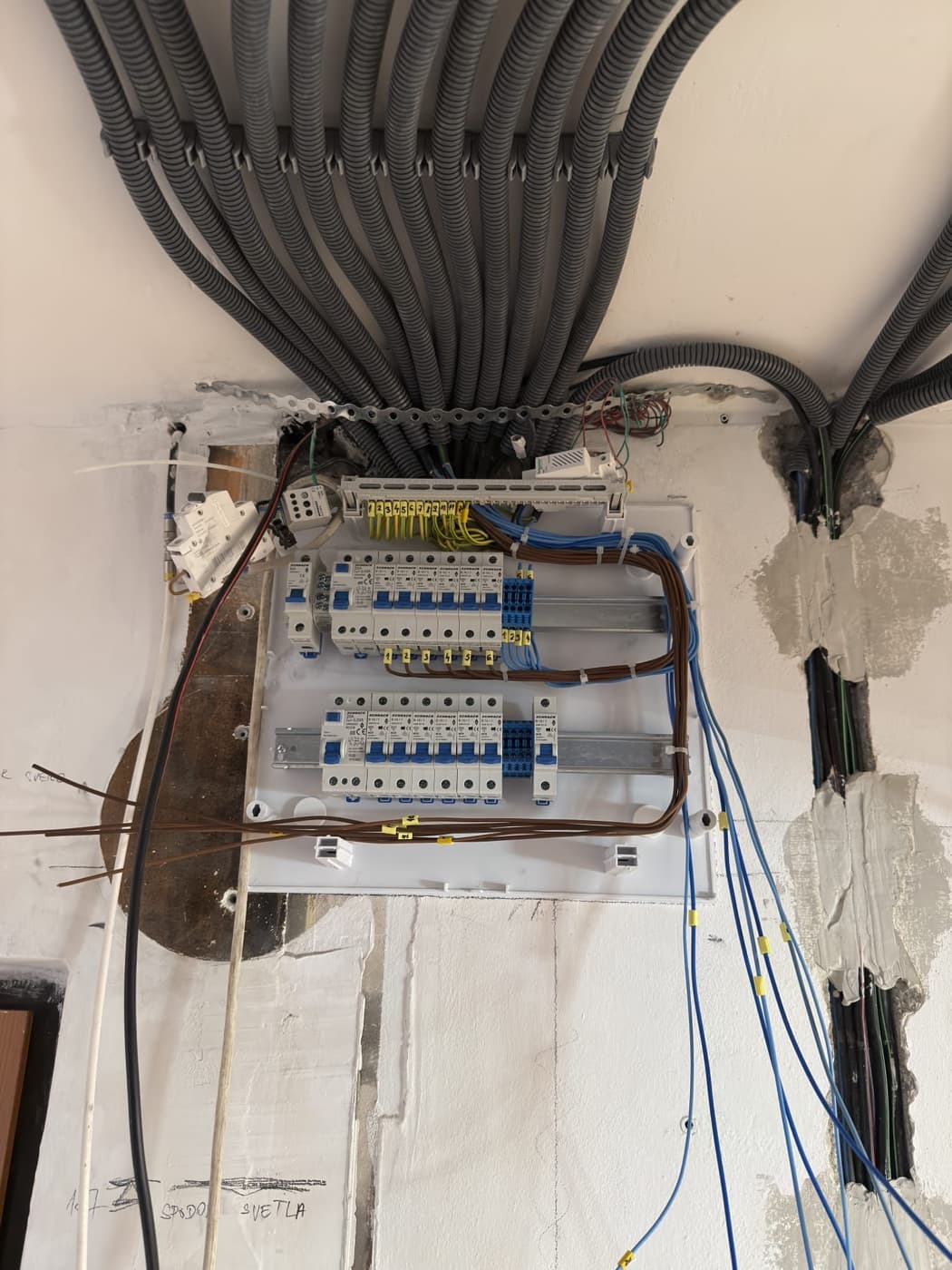 Rozpracovaná elektroinštalácia: rozvádzač a chráničky s káblami